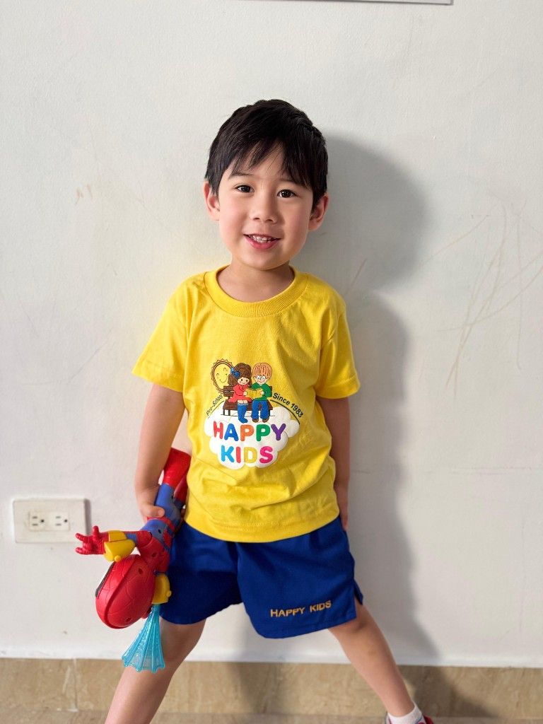 Boy in a Happy Kids outfit holding a Spider-Man toy figure.